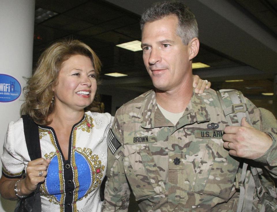 Scott Brown, in uniform poses next to a woman.